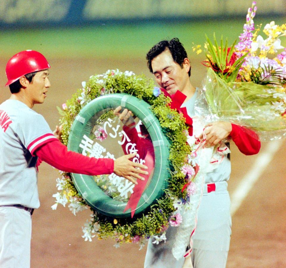 ２００勝をマークし、達川（左）から花束を贈られる北別府＝１９９４年７月、ナゴヤ球場