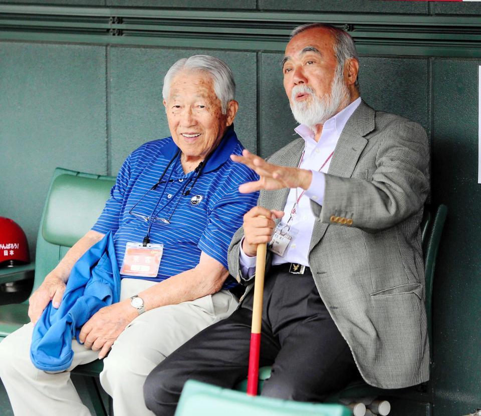 　来日した際にマツダスタジアムの一塁側ベンチで練習を見守る平山智さん（左）。右は安仁屋さん＝２０１５年４月