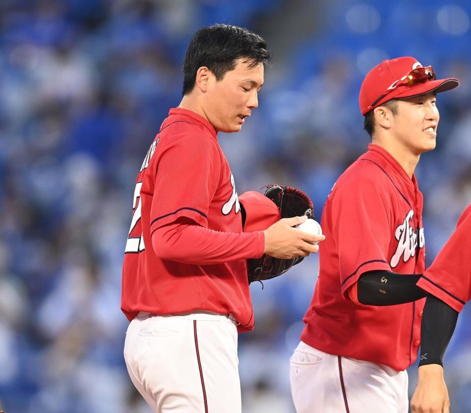 　球団新人タイ記録となる２５セーブ目を挙げ、ウイニングボールを感慨深げに見つめる栗林（中央）＝撮影・高石航平