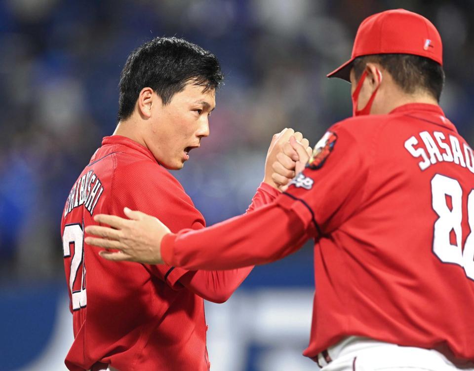 　プロ野球新人タイとなる９連続セーブを挙げ、佐々岡監督（右）とタッチを交わす栗林（撮影・高石航平）