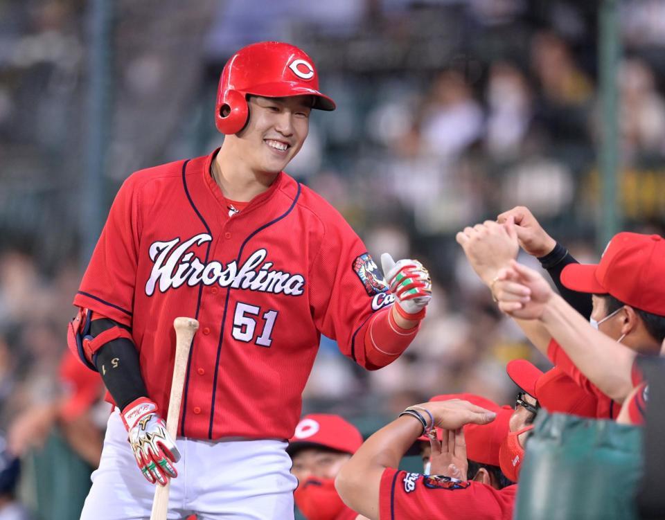 　３回、ソロを放って生還しナインの出迎えに笑顔で応える小園（撮影・立川洋一郎）