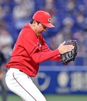 ９回、岡林を空振り三振に仕留めて最後を締め、グラブをたたいて声を上げる栗林（撮影・立川洋一郎）