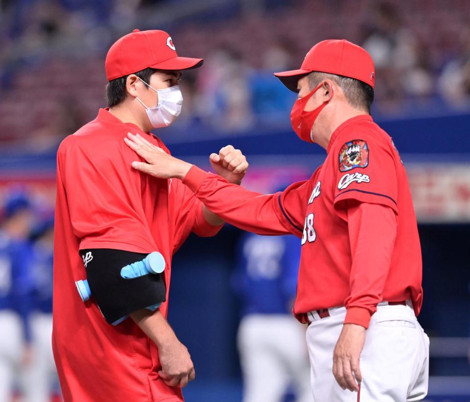 １１勝目を挙げ、佐々岡監督（右）にねぎらわれる九里（撮影・立川洋一郎）