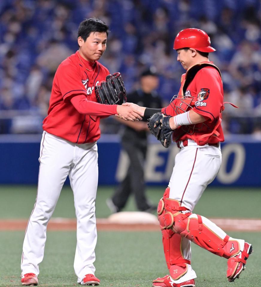 ９回、最後を締めくくり会沢（右）と握手を交わす栗林（撮影・立川洋一郎）