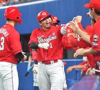  ５回、先制の満塁本塁打を放ち、ナインの祝福に笑顔を見せる広島・鈴木誠