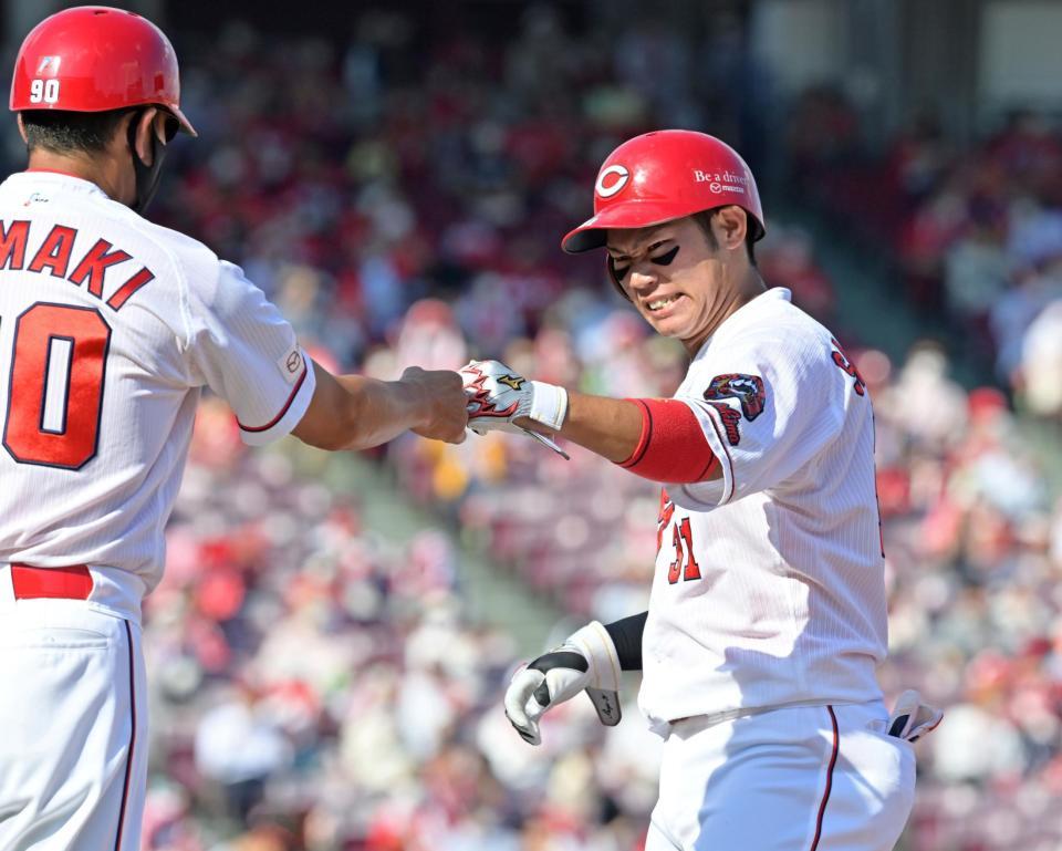 １回、中前へ適時打を放ち、玉木コーチ（左）とタッチを交わす坂倉（撮影・立川洋一郎）