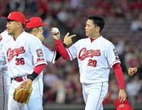 球団新記録となる15試合連続セーブを挙げ、ナインとタッチを交わす栗林（右）＝撮影・立川洋一郎