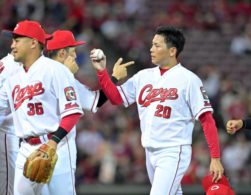 球団新記録となる15試合連続セーブを挙げ、ナインとタッチを交わす栗林（右）＝撮影・立川洋一郎