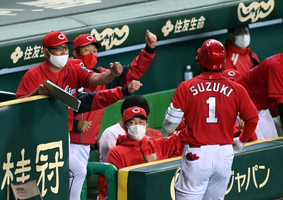 ８回、佐々岡監督（左）から２人目はソロを放った鈴木誠を迎える（撮影・山口登）