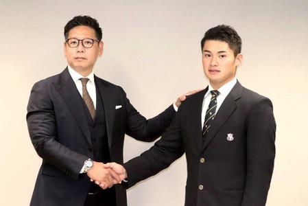 仮契約を終え、松本スカウト（左）と握手をする田村