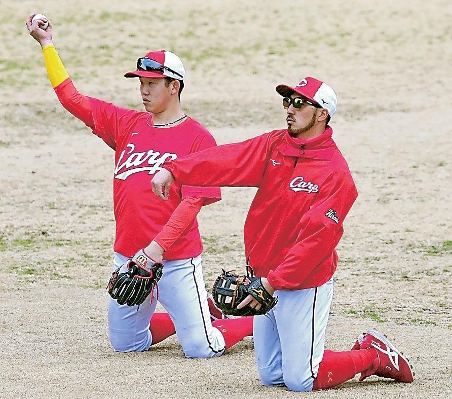 マンツーマンで小園（左）に送球のアドバイスをする菊池涼