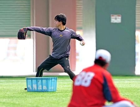 　シート打撃登板後に投球フォームをチェックしながらネットスローをする黒原。手前は佐々岡監督（撮影・立川洋一郎）