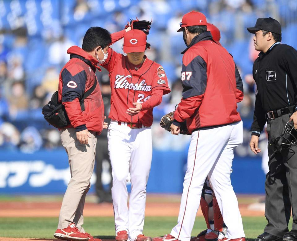 　４回、梶原の打球が当たった左手をトレーナー（左）と高橋投手コーチ（右手前）に見せる黒原