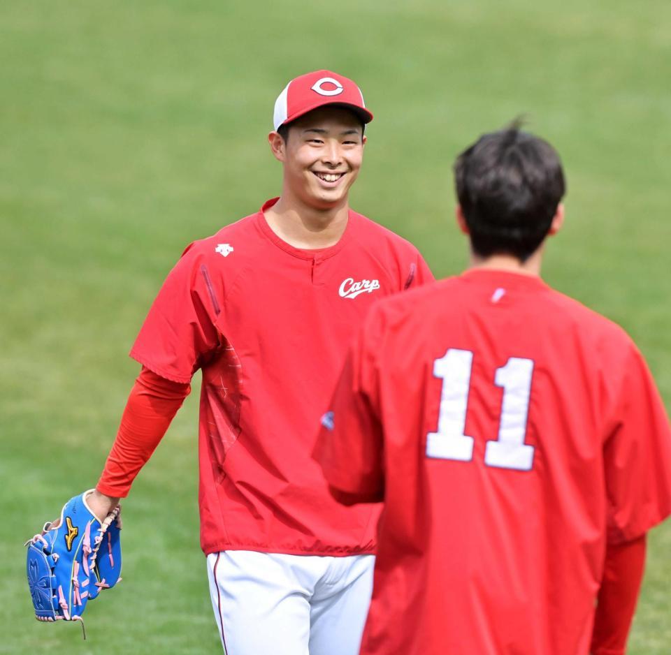 　九里（手前）とのキャッチボールを終えて笑顔を見せる玉村（撮影・立川洋一郎）
