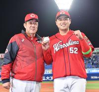 　佐々岡監督（左）から祝福される末包（撮影・佐々木彰尚）