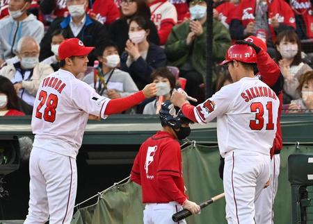 　２回、会沢の先制打で生還した三走の坂倉（右）を迎える床田