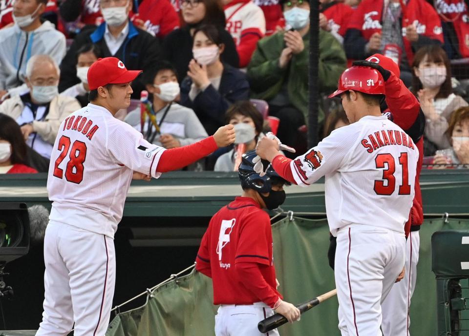 　２回、会沢の先制打で生還した三走の坂倉（右）を迎える床田