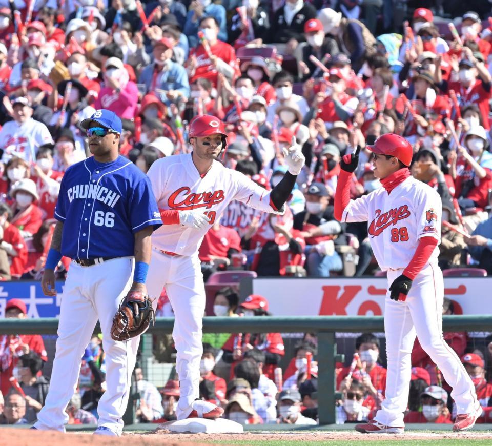 　３回、同点に追いつく２点適時打を放ち小窪コーチ（右）とタッチを交わすマクブルーム（撮影・立川洋一郎）