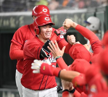 　２回、先制２ランを放ちナインとタッチを交わす坂倉（撮影・棚橋慶太）