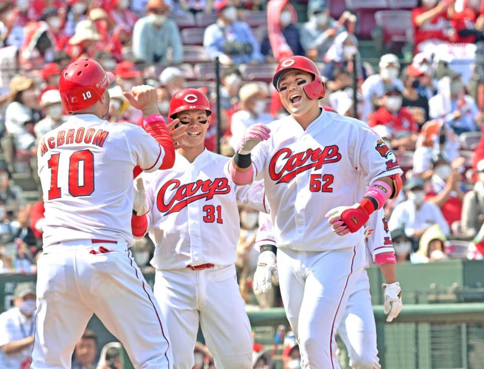 　４回、満塁本塁打を放って生還し笑顔を見せる末包（右）＝撮影・立川洋一郎