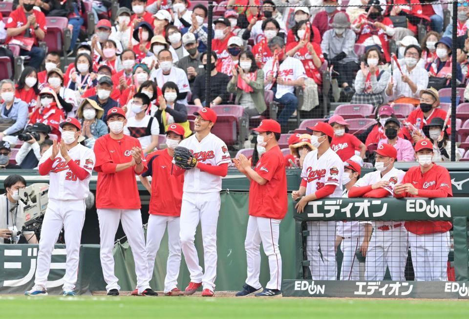 延長１１回表を投げ終えて安堵（あんど）の表情を見せる薮田（中央左）と野手を出迎える広島投手陣（左から）栗林、ケムナ、森浦、薮田、矢崎、塹江とアンダーソン（右端）＝撮影・立川洋一郎