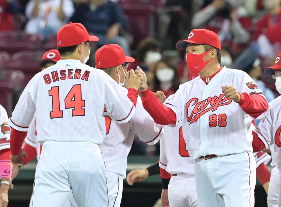 連敗をストップし大瀬良（左）とタッチを交わす佐々岡監督