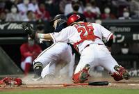 　４回、太田の左前打で本塁に滑り込む二走・野口。アウトとなるが三塁手の走塁妨害との判定で生還が認められる。捕手・会沢