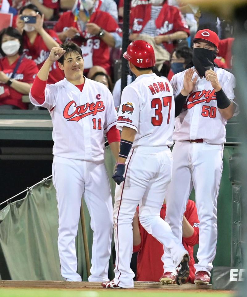 　５回、坂倉が押し出し四球を選び、生還した野間（３７）と笑顔でタッチを交わす九里（左）＝撮影・立川洋一郎