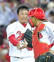 ９回、最後を締めくくり会沢（右）と握手を交わす栗林（撮影・立川洋一郎）