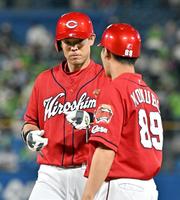 　６回、中前打を放ち、小窪コーチ（右）とタッチを交わす秋山