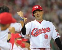 　８回、西川の適時打で生還しナインの出迎えに笑顔を見せる秋山（撮影・立川洋一郎）