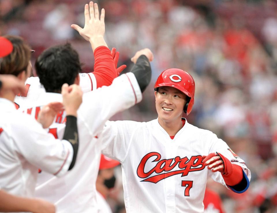 　１回、先頭打者本塁打を放ちナインの出迎えに笑顔で応える堂林（撮影・立川洋一郎）