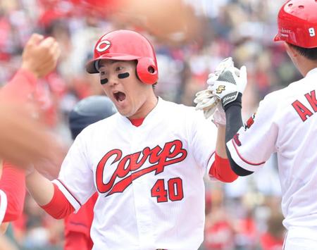 　３回、野間（左）の一ゴロで相手エラーの間に生還。ナインとタッチを交わす磯村（撮影・立川洋一郎）