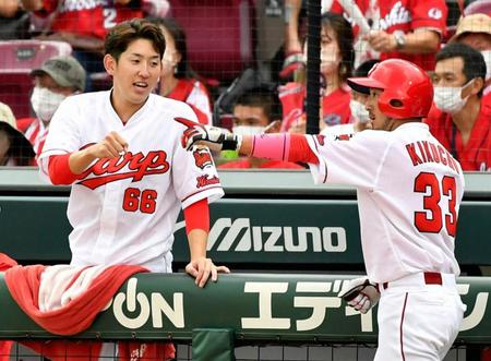 　７回、生還した菊池涼（右）を迎える広島・遠藤＝マツダ