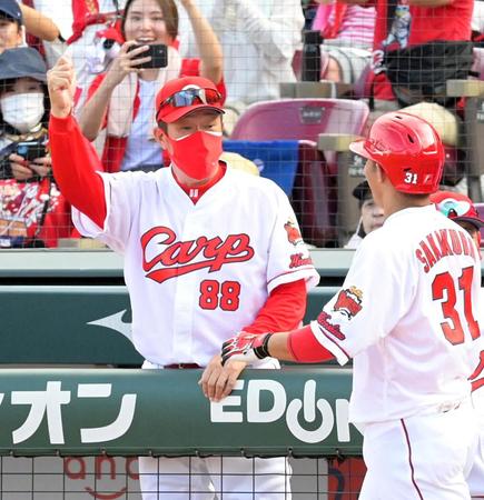 　７回、満塁本塁打を放った坂倉（右）を迎える佐々岡監督（撮影・立川洋一郎）