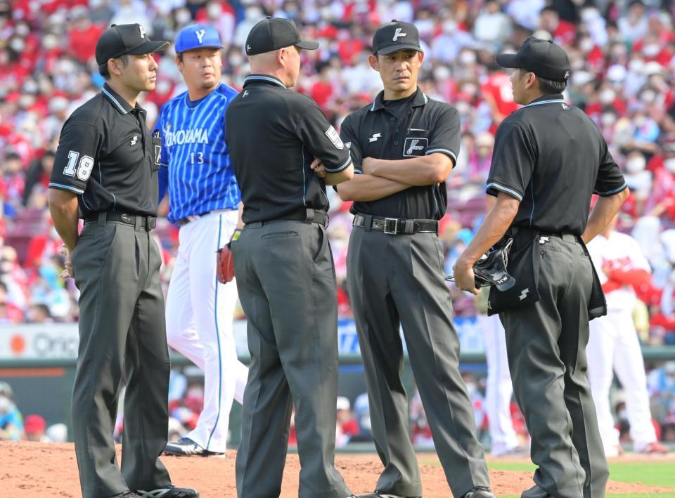 　７回、磯村の死球が当たった箇所について危険球だったかの協議をする審判団（撮影・立川洋一郎）