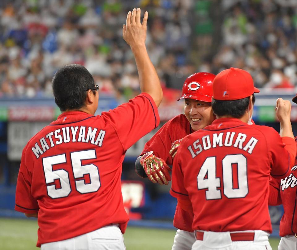 　３回、左越え３ランを放ち、松山（左）の手荒い祝福におびえる堂林（右奥）＝撮影・伊藤笙子