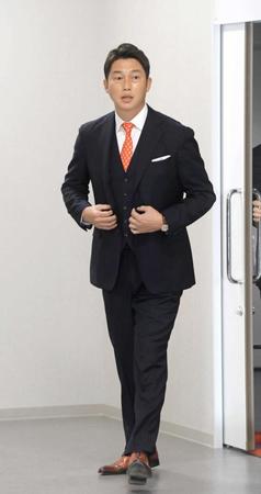 　赤いネクタイに赤い革靴姿で会見へ向かう新井新監督