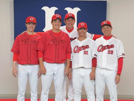 　新ユニホームお披露目記者会見の会場に新井監督（中央）が飛び入り参加。笑顔で記念撮影に応じる（左から）森下、九里（右から）栗林、坂倉＝撮影・立川洋一郎