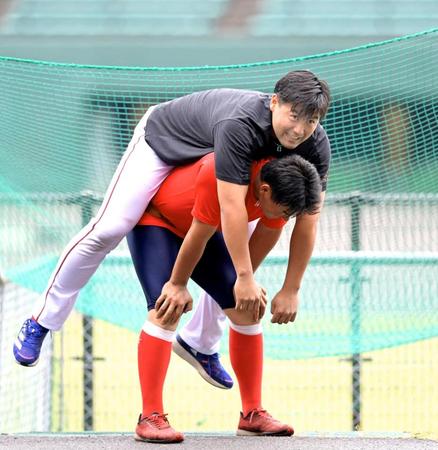 トレーニングをする木下に背負われ笑顔を見せる末包（撮影・立川洋一郎）