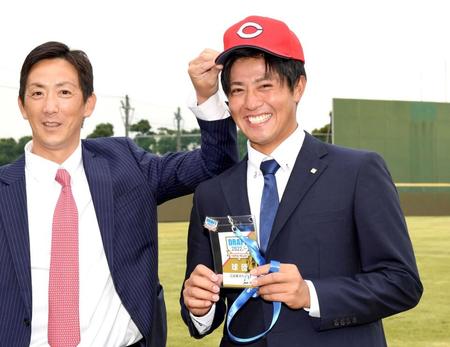 尾形スカウト（左）から帽子をかぶせてもらい笑顔を見せる東京ガス・益田（撮影・佐藤厚）