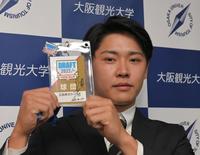 　新井監督サイン入りのドラフトパスを手にする大阪観光大・久保修（撮影・高部洋祐）