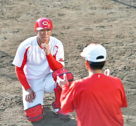 藤井ヘッドコーチ（右）のアドバイスに真剣な表情で聞き入る坂倉（撮影・立川洋一郎）