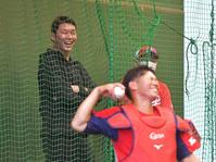 　ブルペン後方から投手のピッチングを見守り笑顔を見せる新井監督。手前は坂倉（撮影・立川洋一郎）