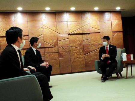 　新井監督の現役引退記念グラスを手に話す湯崎知事（右）と新井監督（中央）