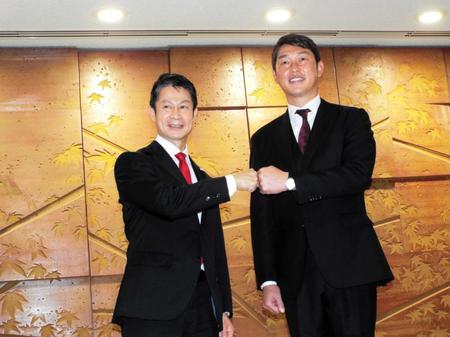 　グータッチをかわす湯崎広島県知事（左）と新井監督