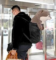 　カワウソのぬいぐるみをおんぶして入寮する内田