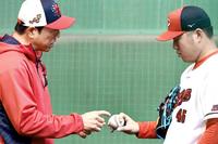 　松本（右）にフォークの握りを伝授する黒田球団アドバイザー（撮影・田中太一）