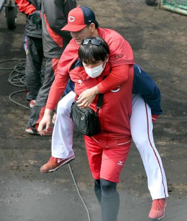 　打撃練習で打球を足に当て、おんぶされながらベンチへ引き揚げる河野