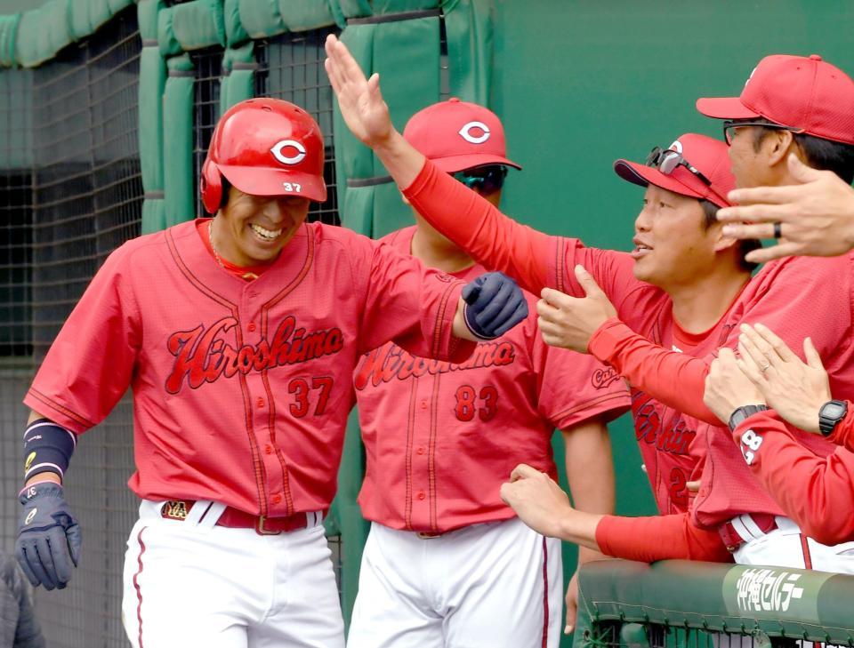 　１回、菊池の適時打で生還した野間の頭をはたいて祝福する新井監督（撮影・田中太一）